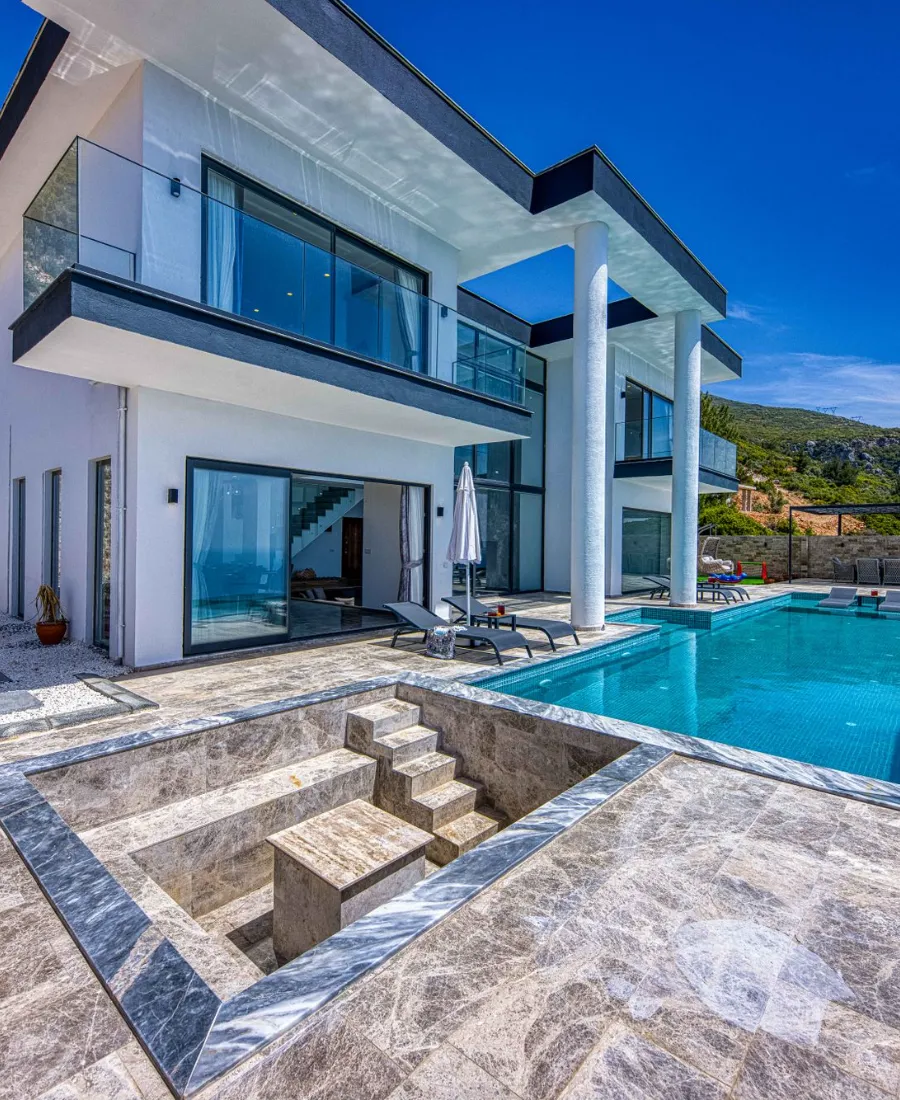 A modern villa with a pool and a stone terrace